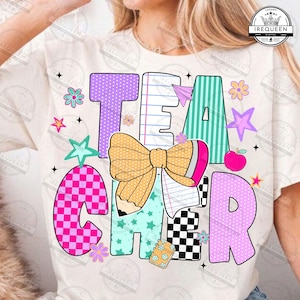 May include: A cream-colored t-shirt featuring the word TEACHER in large, colorful, patterned letters. The design includes a yellow pencil-shaped bow, a small notebook, stars, flowers, and a paper airplane, all in vibrant shades of pink, teal, and purple.