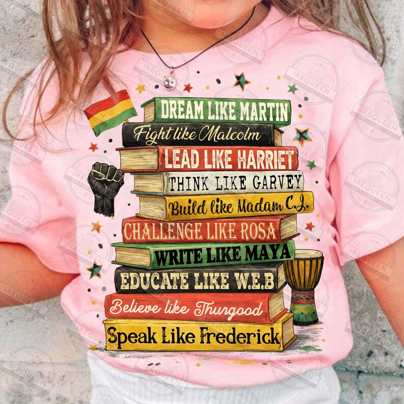 May include: Pink t-shirt featuring a stack of books with inspirational phrases like "Dream Like Martin" and "Fight Like Malcolm." Includes a black power fist, a flag, and stars. A djembe drum is also visible.