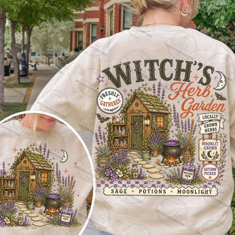 May include: A cream-colored sweatshirt featuring a graphic print of a wooden garden shed surrounded by lavender, a black cauldron, and various herbs. The text reads Witch's Herb Garden, Locally Grown Herbs, Moonlit Grown, Autumn Picked, and Sage Potions.