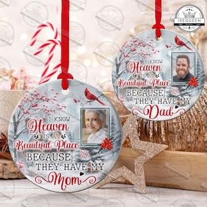 May include: Two round Christmas ornaments with a winter scene and a photo frame. The ornaments feature the text "I know Heaven is a Beautiful Place because they have my Dad/Mom".