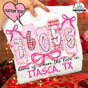 May include: A white pillow with the text "home is where the love in ITASCA, TX". The pillow features the numbers "76055" in pink and red patterns, with pink bows and hearts.