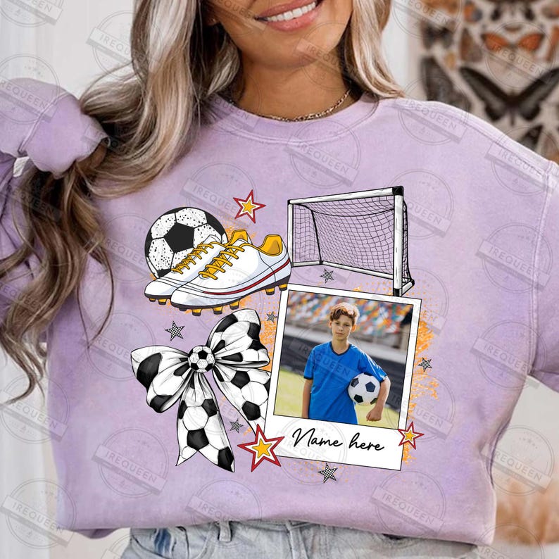 Puede incluir: Una sudadera morada con un dise&ntilde;o de tem&aacute;tica futbol&iacute;stica. El dise&ntilde;o incluye un bal&oacute;n de f&uacute;tbol, botas de f&uacute;tbol, una porter&iacute;a, un lazo y una foto de un joven sosteniendo un bal&oacute;n de f&uacute;tbol. El texto "Name here" est&aacute; impreso en la sudadera.