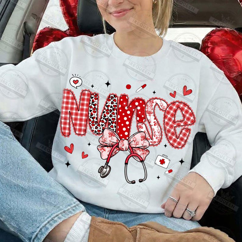May include: White sweatshirt with the word "Nurse" in red, patterned letters. The design includes hearts, a bow, a stethoscope, and medical-themed icons. The sweatshirt is a casual, everyday garment.