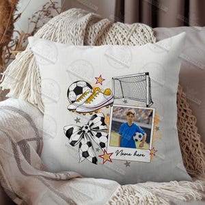 Puede incluir: Una almohada blanca con tem&aacute;tica de f&uacute;tbol. La almohada presenta un bal&oacute;n de f&uacute;tbol, tacos, una porter&iacute;a, un lazo y una foto de un ni&ntilde;o peque&ntilde;o sosteniendo un bal&oacute;n de f&uacute;tbol. El texto "Nombre aqu&iacute;" est&aacute; impreso en la almohada.