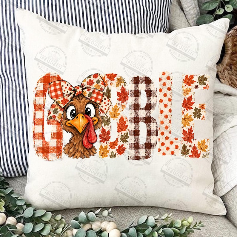 May include: A square throw pillow featuring the word GOBBLE in large letters. The letters are decorated with orange buffalo plaid, autumn leaf patterns, and orange polka dots. A cartoon turkey with a large plaid bow sits in the letter O.