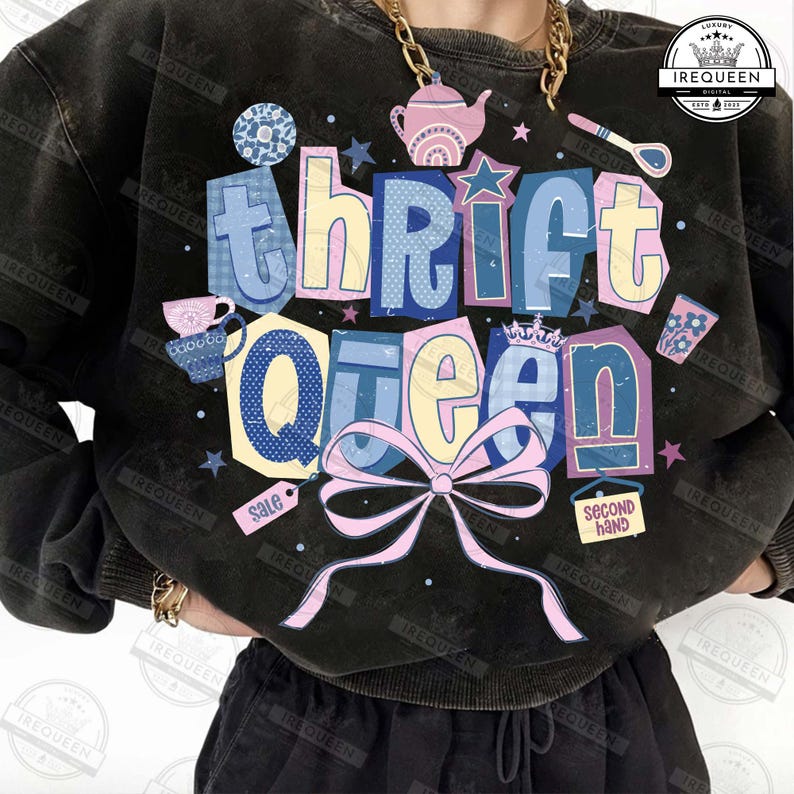May include: Black sweatshirt with the text "Thrift Queen" in colorful block letters. The design includes a pink bow, stars, and illustrations of a teapot, teacup, and other thrifted items. The sweatshirt has a vintage, washed look.