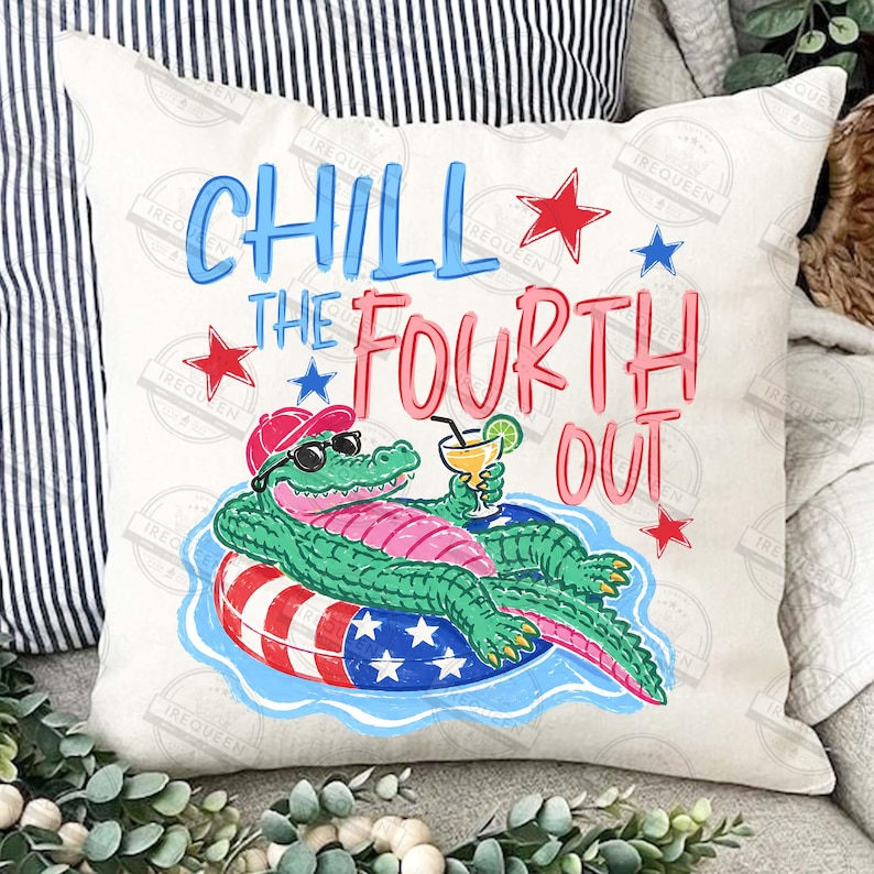 May include: A square cushion featuring a cartoon alligator in sunglasses and a red cap, floating on a pool ring and holding a cocktail. The text reads "CHILL THE FOURTH OUT". The design includes red and blue stars.