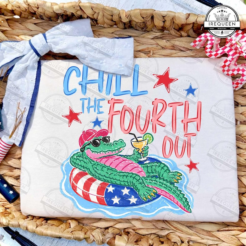 May include: A white t-shirt featuring a cartoon alligator in sunglasses and a red hat, holding a cocktail on an inflatable ring. The text "Chill the Fourth Out" is in blue and pink. Red and blue stars complete the design.
