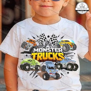 Op de afbeelding: Wit T-shirt met een kleurrijke afbeelding van vijf monstertrucks in actie. Het ontwerp bevat de tekst "MONSTER TRUCKS" in het geel en geblokte vlaggen. De trucks zijn in verschillende kleuren en ontwerpen.