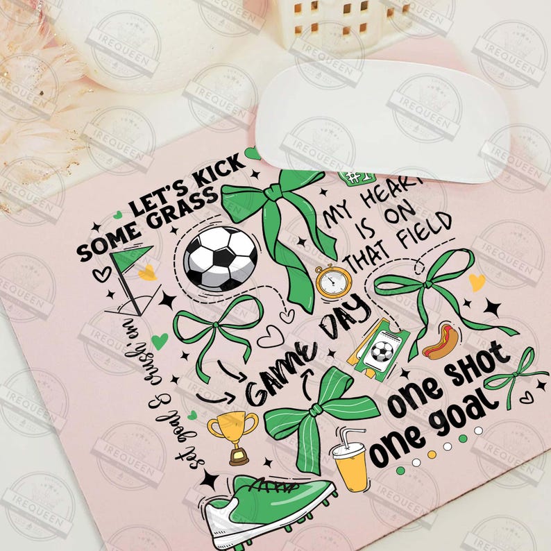 May include: A pink and green mousepad with a soccer theme. It features a soccer ball, a trophy, a hot dog, a drink, and a shoe. The text on the mousepad reads "Let's kick some grass", "Game Day", "My heart is on that field", "One shot one goal".