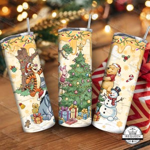 May include: Three stainless steel tumblers with festive Christmas designs. One features Tigger, Eeyore, and gifts; another has Piglet decorating a tree; the last shows Winnie the Pooh and a snowman. Each has a straw and a yellow dripping design.