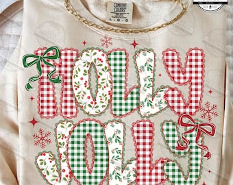 Puede incluir: Sudadera color crema con las palabras "HOLLY JOLLY" en un diseño festivo. Las letras presentan patrones de cuadros rojos y verdes, acentos florales y lazos decorativos. La sudadera tiene cuello redondo y mangas largas.