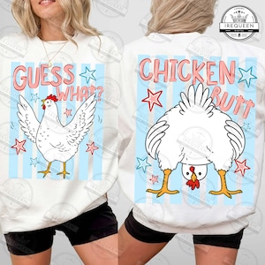 May include: White sweatshirt with a cartoon chicken design. The front says "GUESS WHAT?" with a chicken illustration and stars. The back says "CHICKEN BUTT" with a chicken's rear end and stars. Blue and white striped background.