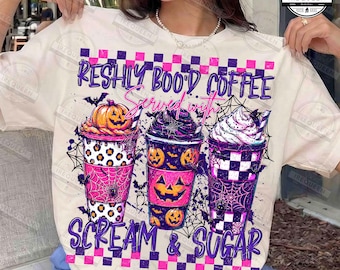 Puede incluir: Una camiseta color crema con un gráfico de tres tazas de café con temática de Halloween. El texto dice "FRESHLY BOO'D COFFEE SERVED WITH SCREAM & SUGAR". El diseño incluye calabazas, telarañas, murciélagos y patrones de cuadros en morado, rosa y negro.