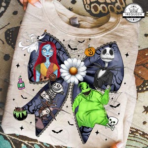 May include: A beige sweatshirt featuring a large bow design with characters from The Nightmare Before Christmas. The bow includes images of Sally, Jack Skellington, Oogie Boogie, and a daisy. Bats, spiderwebs, and a pumpkin are also included.