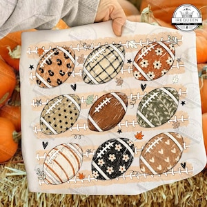 May include: A white t-shirt featuring a graphic print of nine American footballs arranged in three rows. Each football displays a unique pattern, including leopard print, plaid, floral, polka dots, and hearts, interspersed with small leaves and stars.