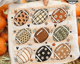 May include: A white t-shirt featuring a graphic print of nine American footballs arranged in three rows. Each football displays a unique pattern, including leopard print, plaid, floral, polka dots, and hearts, interspersed with small leaves and stars.