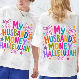 Pu&ograve; includere: Una t-shirt bianca con il testo colorato My Husband's Money Hallelujah in un carattere giocoso. Il design &egrave; decorato con piccoli fiocchi rosa a pois e varie stelle multicolori sparse attorno alla scritta sulla parte anteriore.