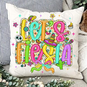 May include: A cushion cover with the phrase "Let's Fiesta" in bright, outlined lettering. The design features a sombrero, maracas, a taco, and floral patterns on a white backdrop.