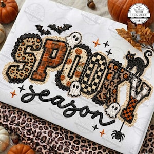 May include: A white t-shirt featuring the embroidered text SPOOKY SEASON. The letters are filled with various patterns including leopard print, orange plaid, pumpkins, and checkers. The design includes small ghosts, bats, a black cat, and a spider.