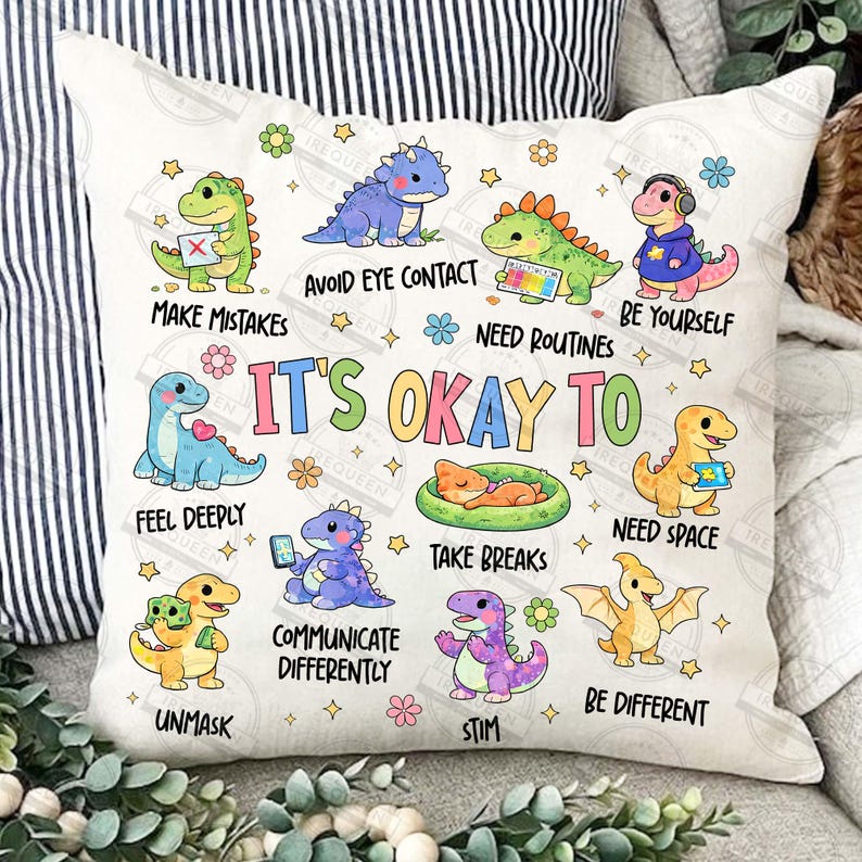 May include: A square cushion with a dinosaur design in various colours. The cushion features cartoon dinosaurs with phrases such as "It's Okay To Feel Deeply" and "Be Yourself". The design includes flowers and stars.