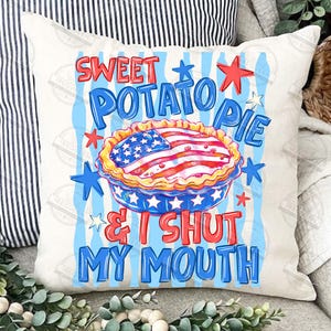 May include: A white pillow with a patriotic design. The pillow features the text "Sweet Potato Pie & I Shut My Mouth" in red and blue. A pie with an American flag design is in the center, surrounded by stars.