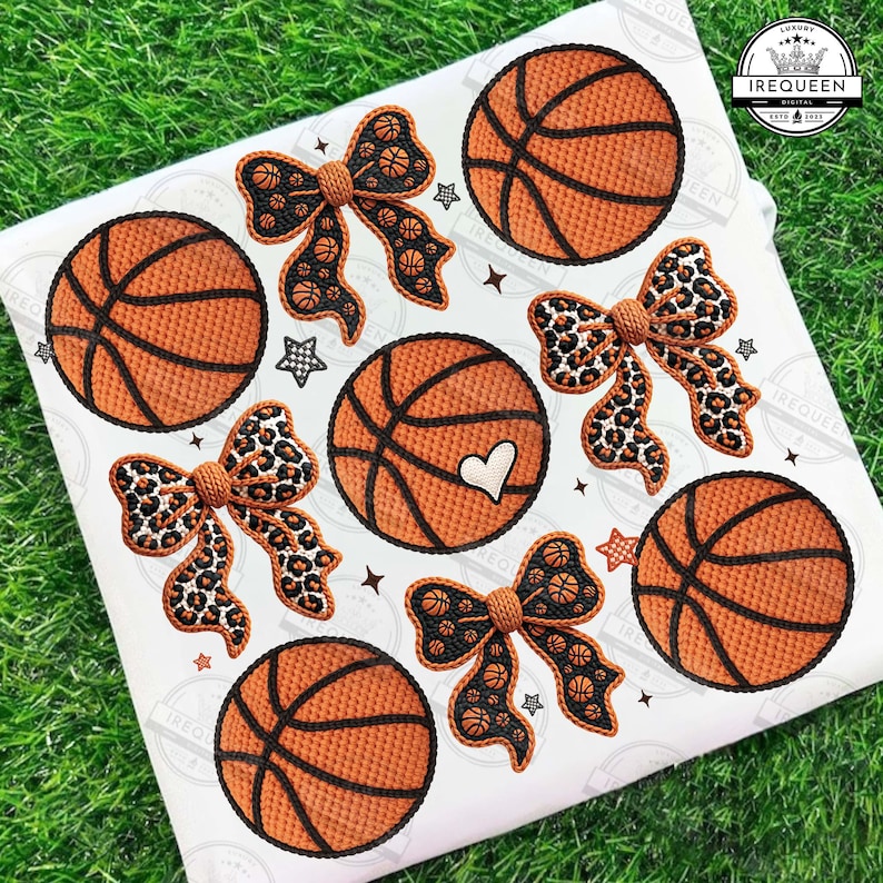 May include: A white fabric with basketball and bow designs. The basketballs are orange with black lines, and the bows have basketball or leopard print patterns. Small star shapes are scattered around the designs.