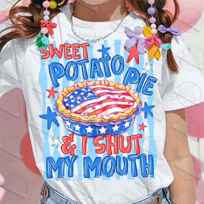 May include: White t-shirt with a patriotic design featuring a sweet potato pie decorated with the American flag. The text reads "SWEET POTATO PIE & I SHUT MY MOUTH" in blue and red. The design includes stars.