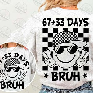Pu&ograve; includere: Una felpa grigio chiaro con un design grafico sul retro. Il design presenta una faccina sorridente con occhiali da sole e un berretto a scacchi, con il testo "67+33 DAYS" sopra e "BRUH" sotto. Il design include un motivo a scacchi in bianco e nero.