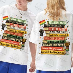 May include: White t-shirts with a colorful graphic design featuring a stack of books. The books have titles like "Dream Like Martin" and "Speak Like Frederick." A black fist and a flag are also included in the design.