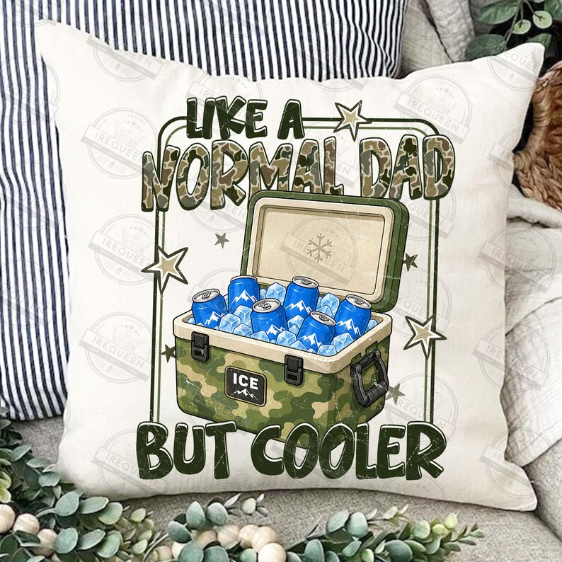 May include: A white throw pillow with a camouflage cooler graphic. The cooler is open, filled with ice and blue cans. Text reads "LIKE A NORMAL DAD BUT COOLER" in green and camouflage lettering.
