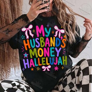 Pu&ograve; includere: Una maglietta nera a maniche lunghe con il testo colorato "My Husband's Money Hallelujah" in un carattere audace e multicolore. Il design &egrave; arricchito da fiocchi bianchi a pois, piccole stelle e scintille nei toni del rosa, blu, arancione e giallo.