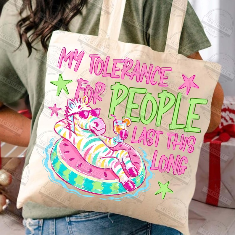 Puede incluir: Bolso tote beige con el texto "MY TOLERANCE FOR PEOPLE LAST THIS LONG" en rosa y verde. Presenta un cebra con gafas de sol flotando en una boya con forma de sand&iacute;a.