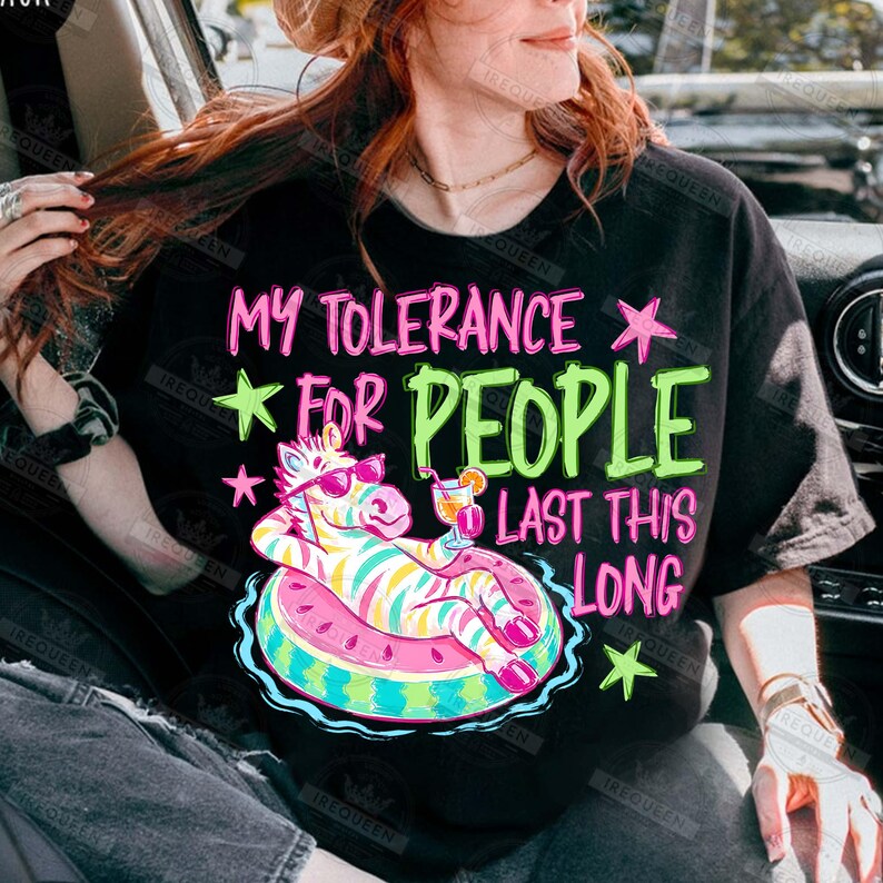 Puede incluir: Camiseta negra con el texto "MY TOLERANCE FOR PEOPLE LAST THIS LONG" en rosa y verde. El gr&aacute;fico presenta una cebra con gafas de sol flotando en un flotador con forma de sand&iacute;a con un c&oacute;ctel.