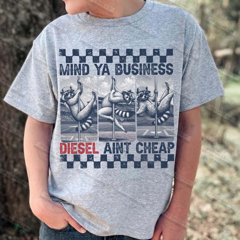 May include: A light gray t-shirt featuring a graphic of three raccoons pole dancing. The text "MIND YA BUSINESS" is above the raccoons, and "DIESEL AINT CHEAP" is below. The design includes a checkered pattern.