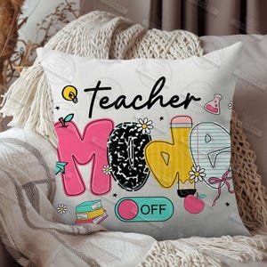 May include: White throw pillow with a colorful graphic that says "Teacher Mode Off". The graphic includes a lightbulb, a pencil, a book, a flower, and a red apple.