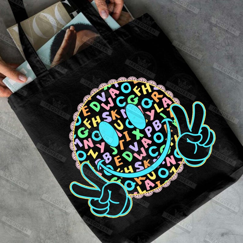 May include: Black tote bag featuring a colorful smiley face design. The smiley face is composed of various letters and symbols, with peace signs on each side. The bag is made of a durable material and is suitable for carrying books or groceries.