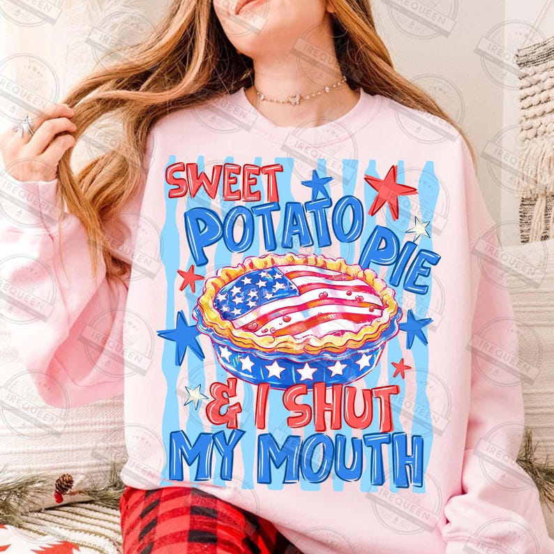 May include: Pink sweatshirt with a graphic of a sweet potato pie decorated with the American flag. The text reads "SWEET POTATO PIE & I SHUT MY MOUTH" in blue and red. The design includes stars and stripes.