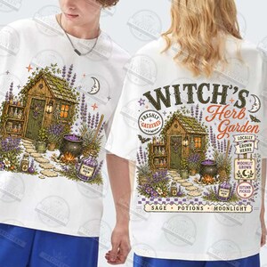 May include: A white t-shirt featuring a graphic illustration of a wooden cottage surrounded by lavender, a cauldron, and potion bottles. The back design includes the text "WITCH'S Herb Garden", "FRESHLY GATHERED", "LOCALLY GROWN HERBS", "MOONLIT GROWN", "AUTUMN PICKED", and "SAGE POTIONS MOONLIGHT".