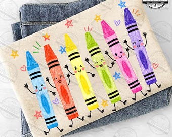 May include: A cream-colored t-shirt featuring a graphic print of six anthropomorphic crayons in blue, orange, yellow, green, pink, and purple. Each crayon has a smiling face, arms, and legs, surrounded by small colorful stars and hearts.