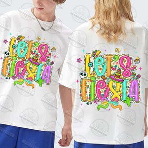 May include: White t-shirts featuring a vibrant "Let's Fiesta" design. The graphic includes a sombrero, cactus, and floral patterns in bright colours. The shirts are short-sleeved and have a relaxed fit, perfect for a celebration.