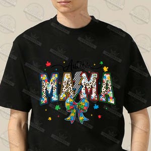 May include: Black t-shirt with the text "Autism Mama" in colorful puzzle piece letters. The letters are decorated with leopard print and a lightning bolt. A blue, yellow, and green puzzle piece bow is below the text.