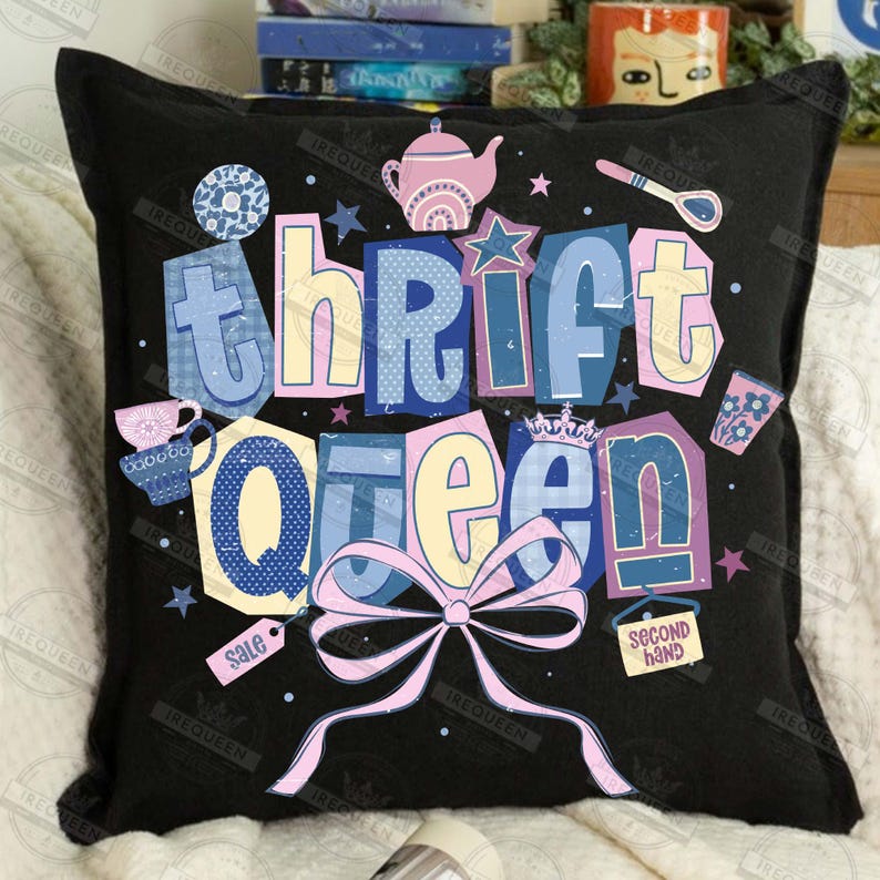 May include: Black throw pillow with the words "thrift queen" in colorful, whimsical lettering. The design includes illustrations of a teapot, teacup, stars, and a bow. The pillow has a tag that says "sale".