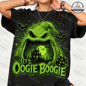 May include: A black t-shirt featuring a large, green, stitched character with a wide-open mouth revealing a haunted house, a full moon, and bats. The text 'LET'S OOGIE BOOGIE' appears in green below the character, flanked by two black dice.