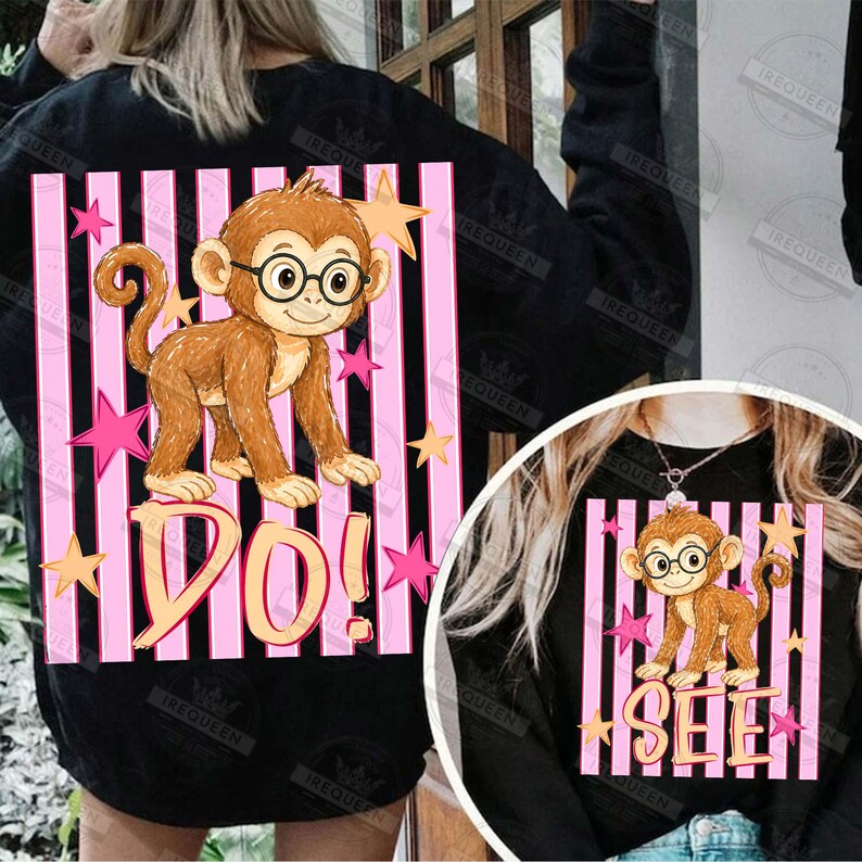 Puede incluir: Sudadera negra con un mono de dibujos animados con gafas, sobre rayas verticales rosas y negras. Las palabras "DO!" y "SEE" est&aacute;n debajo del mono, con acentos de estrellas.
