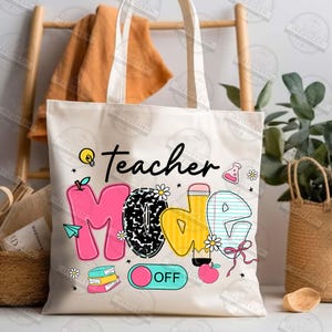 May include: White canvas tote bag with the words "teacher mode" in colorful letters. The letters are decorated with school-themed graphics like a lightbulb, pencil, apple, and books. The words "OFF" are on a pink and blue toggle switch.