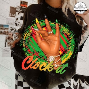 Puede incluir: Camiseta negra con una ilustración de una mano con uñas largas y coloridas, un anillo y un reloj. La mano está frente a un diseño circular verde, rojo y amarillo. El texto "Clock it" está escrito en naranja, amarillo y verde.