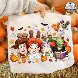 May include: A white fabric print featuring cartoon characters Woody, Jessie, Buzz Lightyear, and Rex dressed in Halloween costumes. The design includes pumpkins, autumn leaves, ghosts, bats, and a purple book titled Boo Spell.