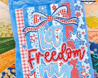 Puede incluir: Camiseta azul claro con un diseño patriótico. La camiseta presenta el texto "Let Freedom Ring" en rojo y azul, junto con estrellas y un lazo. El diseño incorpora cuadros rojos y blancos y lunares azules.