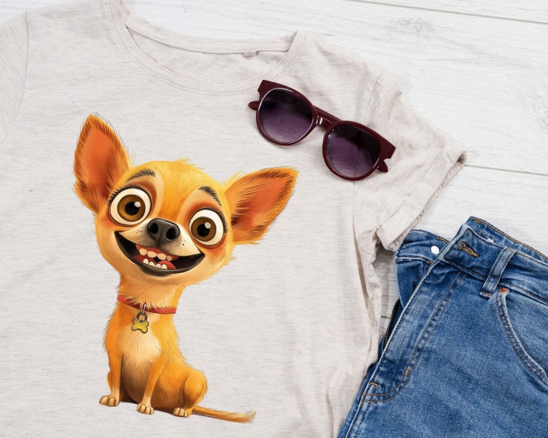 May include: A light grey t-shirt with a cartoon image of a smiling chihuahua wearing a red collar with a bone charm. The chihuahua has large brown eyes and a light brown and orange coat. A pair of dark brown sunglasses are lying on the t-shirt.